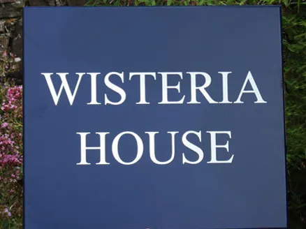 title here Steel blue painted house sign with white letters