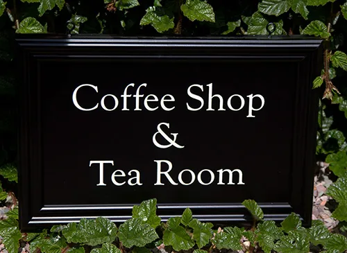 Painted moulded sign, black background with white lettering