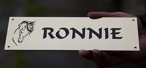 Engraved horse name plate displayed in equestrian yard