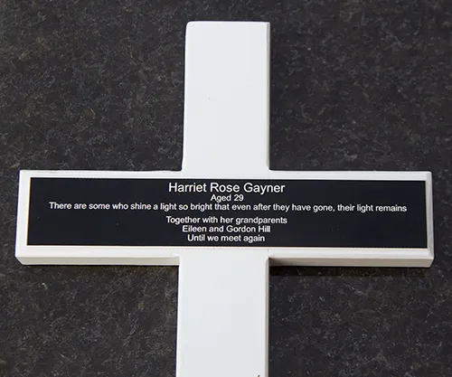 White painted cross with black engraved plaque