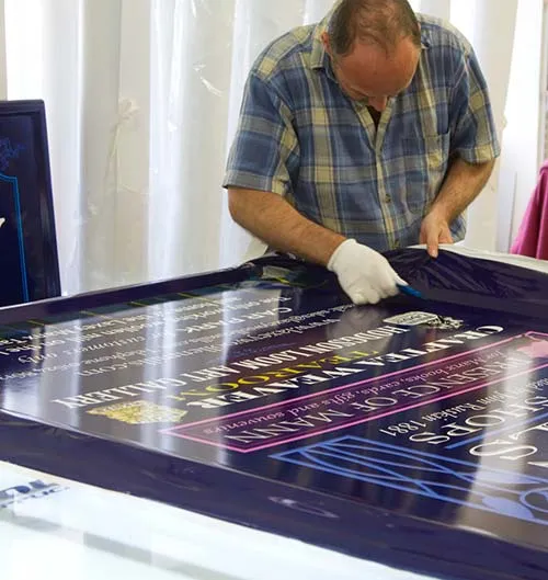 Printed wrap vinyl being applied to a fibreglass-sign board. Applying Vinyl Wrap