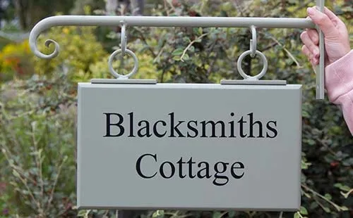 The wought iron bracket can be painted the same colour as the hanging sign. Hanging House Sign in Painted Hardwood